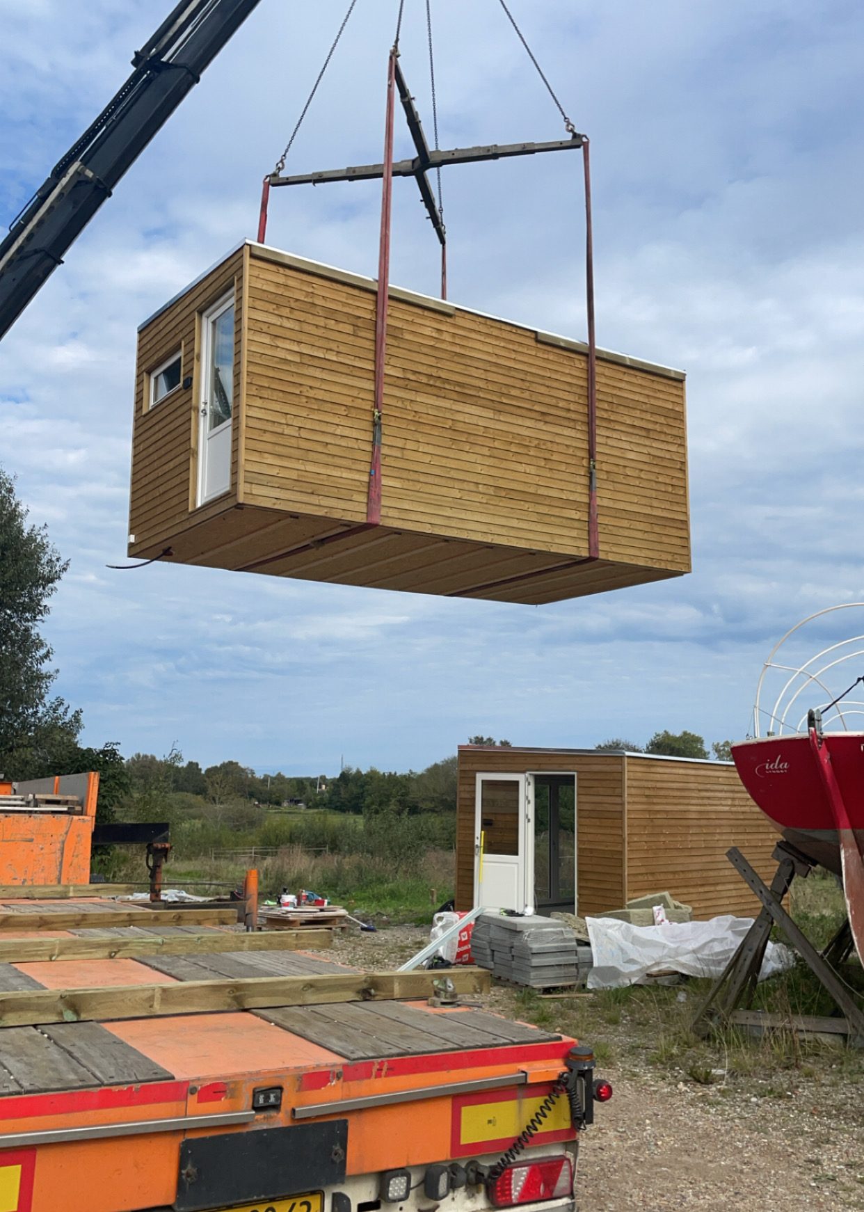 Transportabelt anneks løftes op på ladet af en lastbil – nem transport og installation.