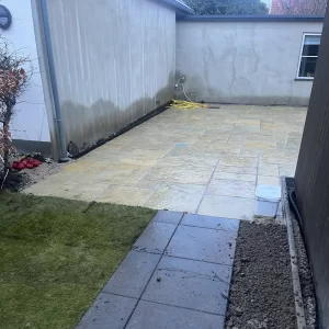 Fliseterrasse i sandsten anlagt i niveau med haven